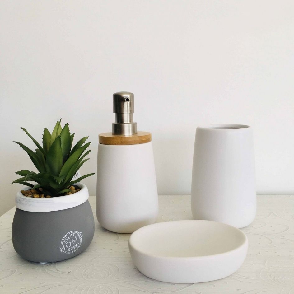 Conjunto de acessórios de casa de banho em cerâmica branca com doseador, copo, saboneteira e vaso com planta artificial