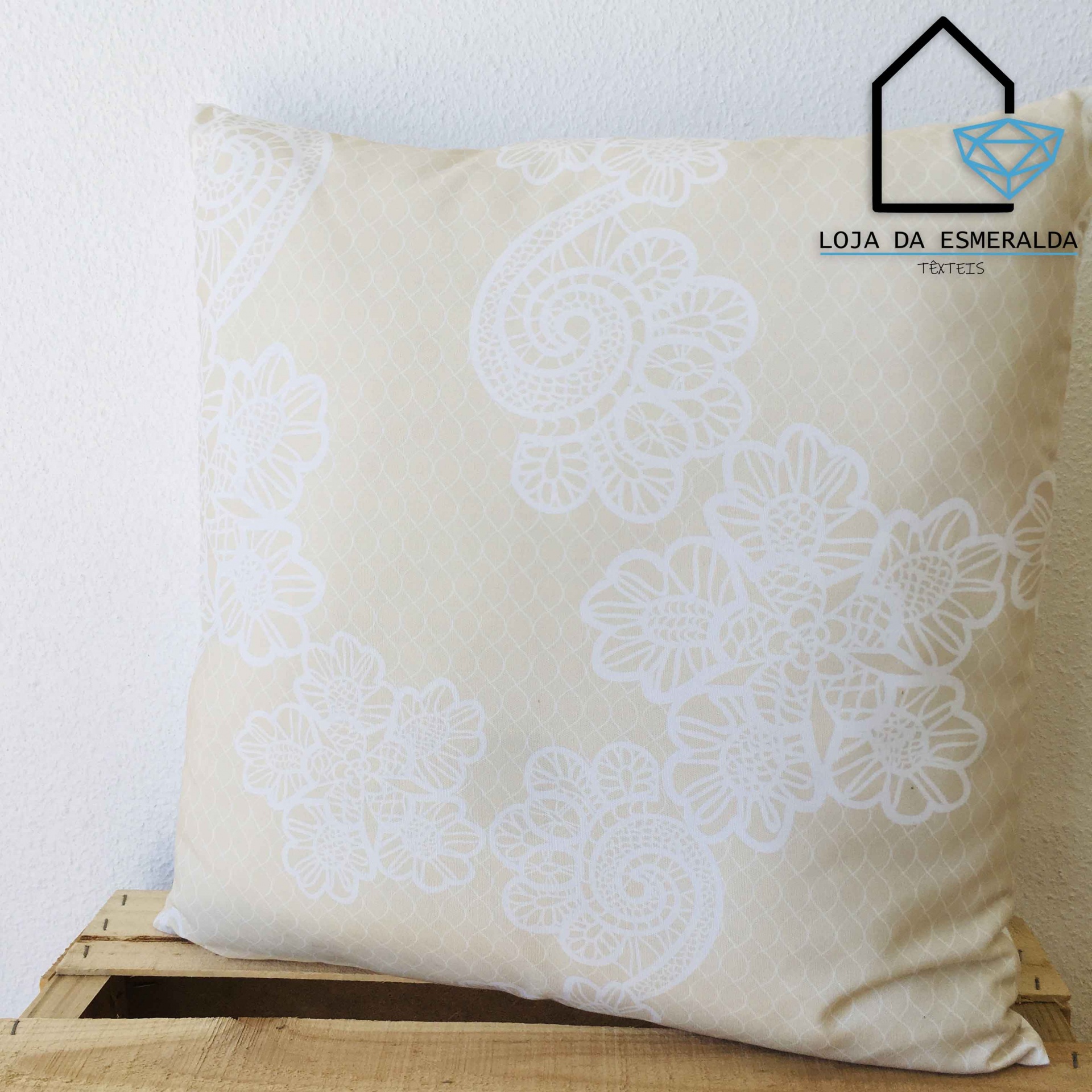 Almofada bege com padrão floral branco numa caixa de madeira