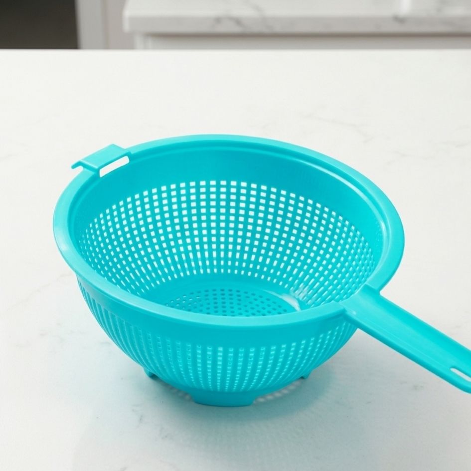 Passador azul turquesa de plástico com punho numa superfície branca