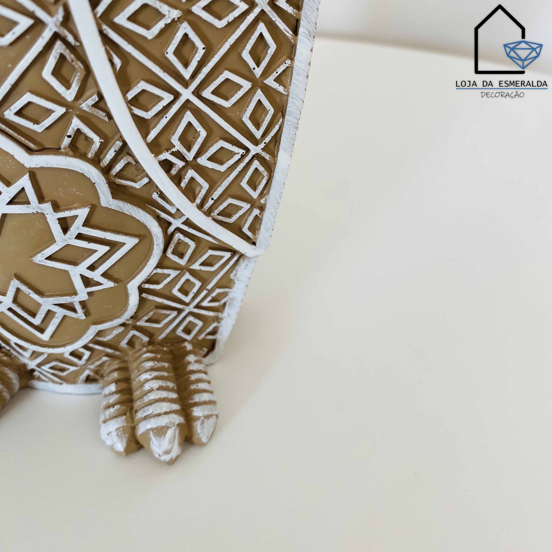 figura decorativa bege com padrões brancos e pés escultóricos em superfície branca