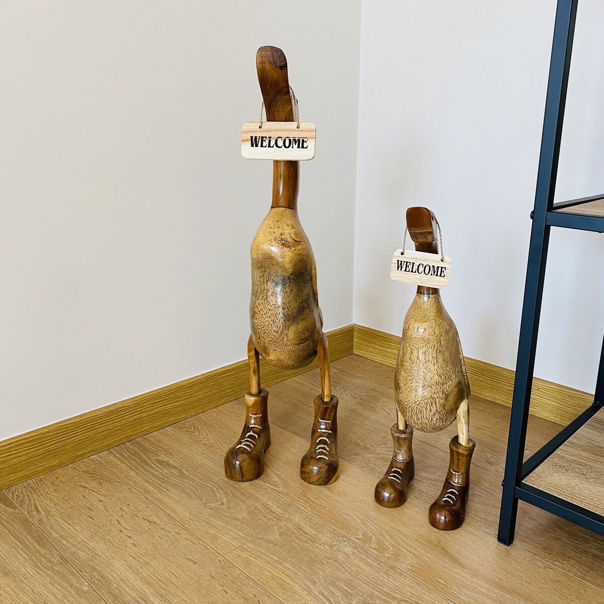 Esculturas de madeira de patos com placas 'WELCOME'