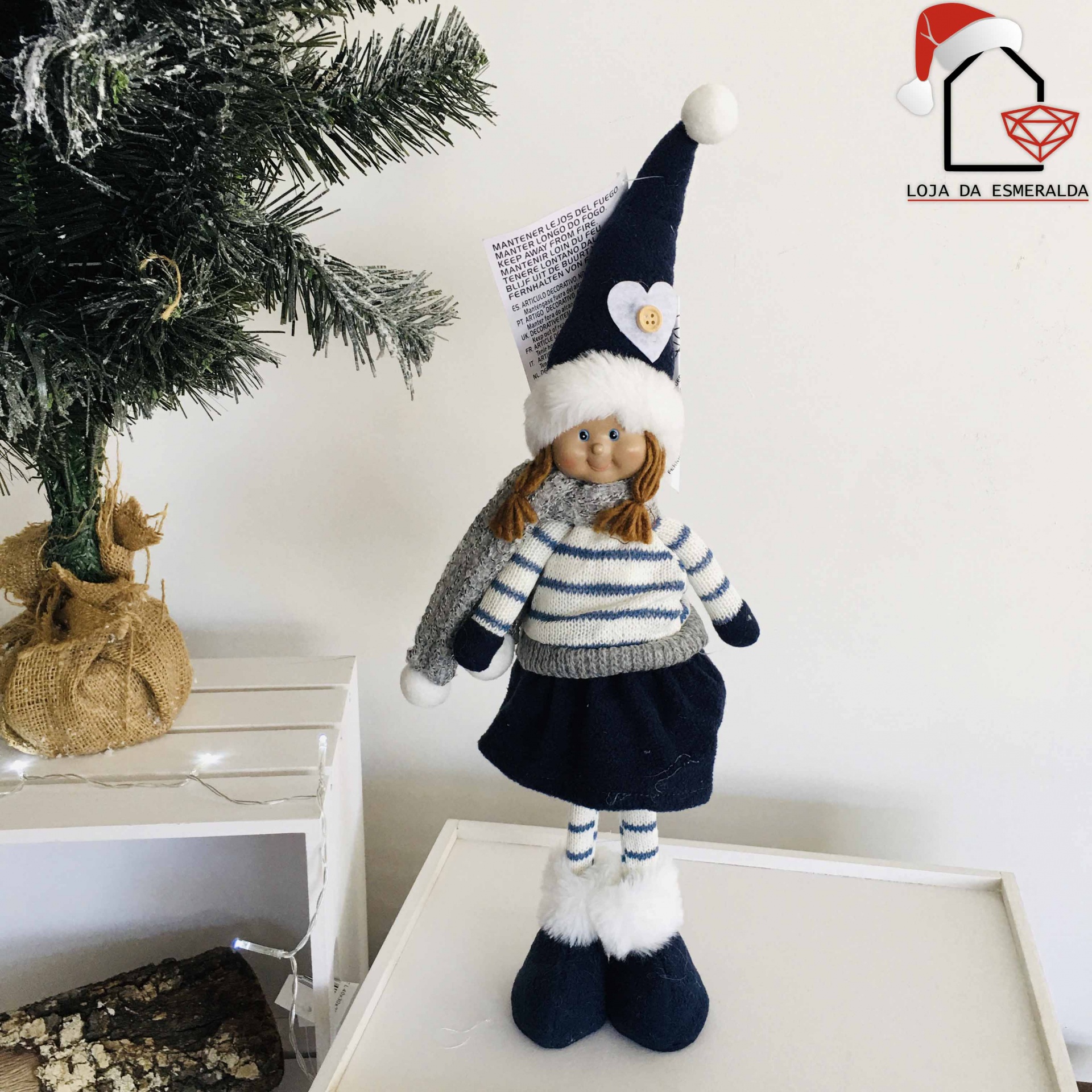 Boneca decorativa vestida com camisola às riscas azul e branca, saia azul, botas azuis com pêlo branco e chapéu azul com pompom branco