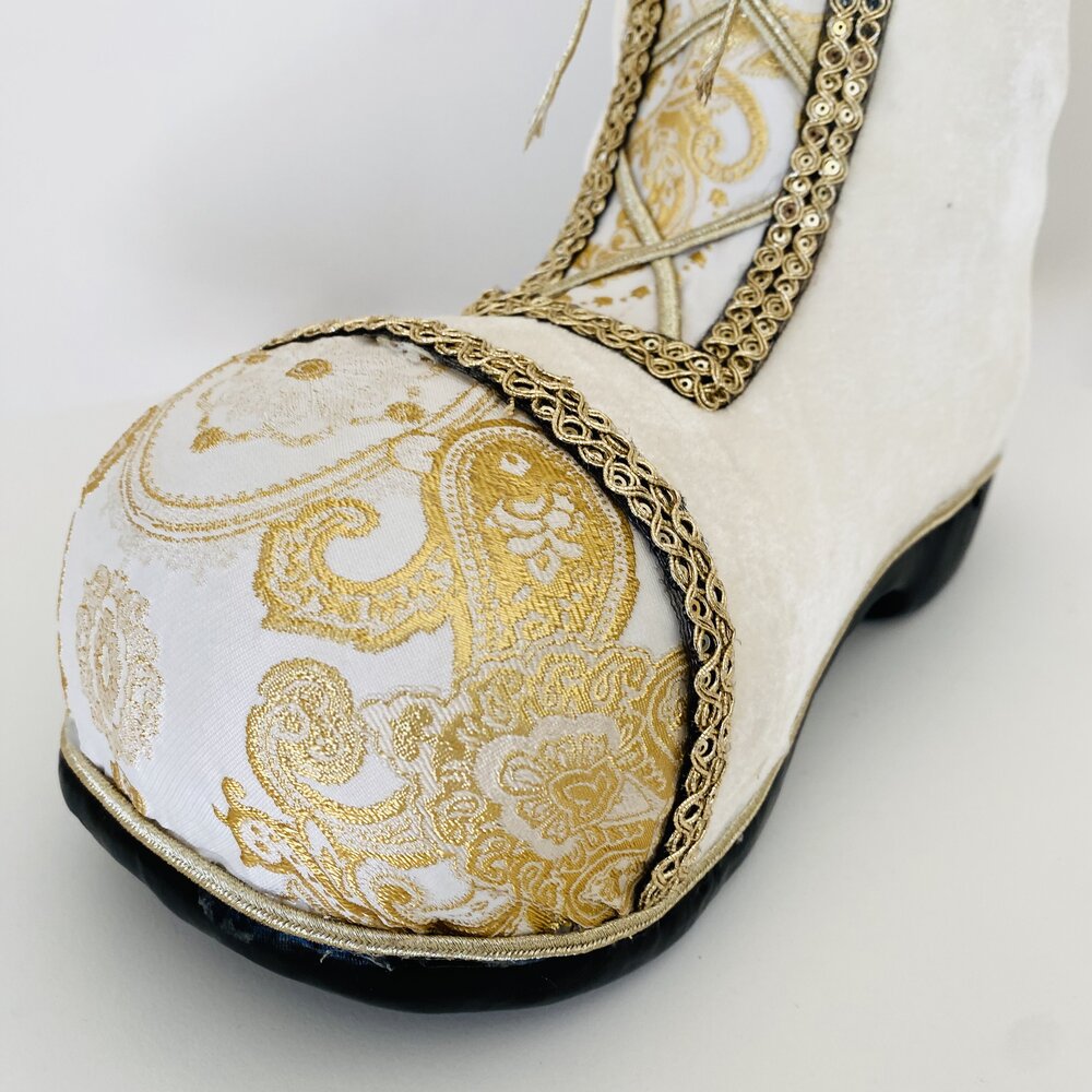 Sapato branco com padrão dourado e sola preta