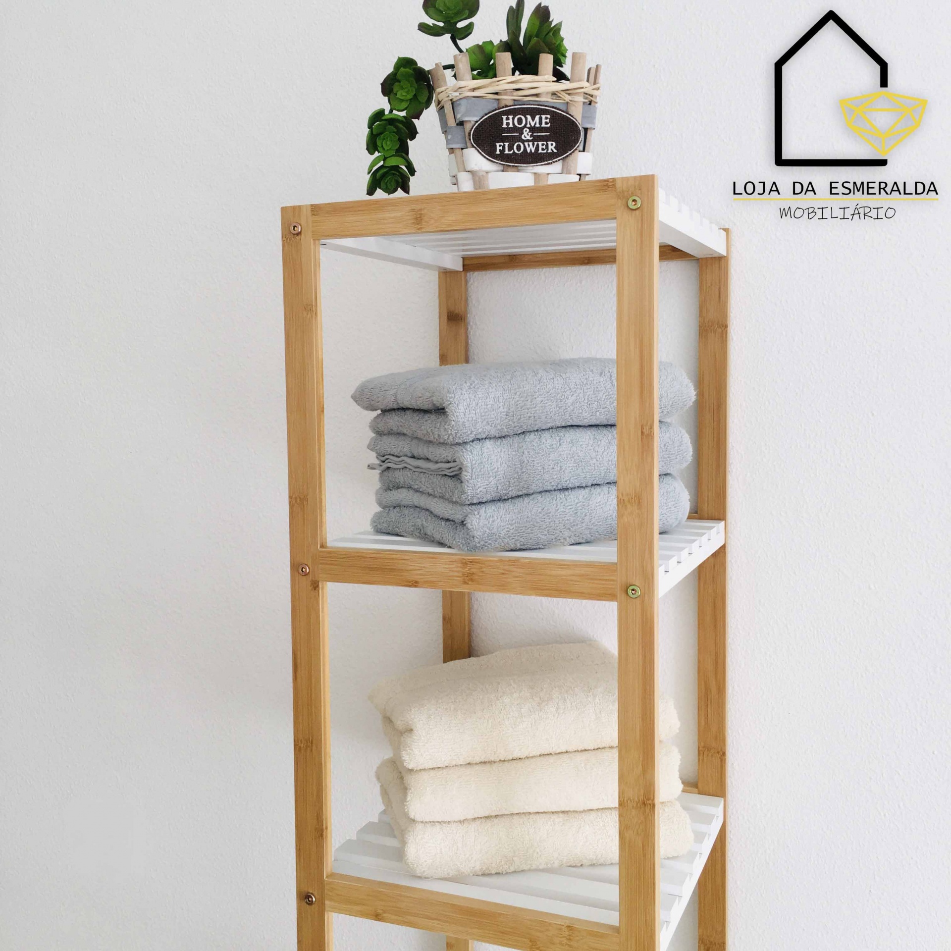 Estante de madeira clara com toalhas e planta decorativa