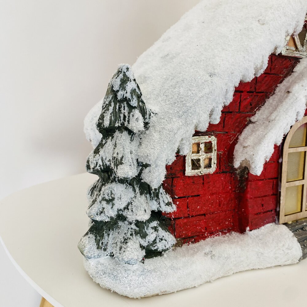 Casa decorativa vermelha com neve artificial e árvore de neve