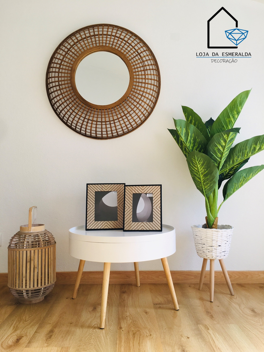 Espelho redondo em moldura de vime e elementos de decoração numa sala