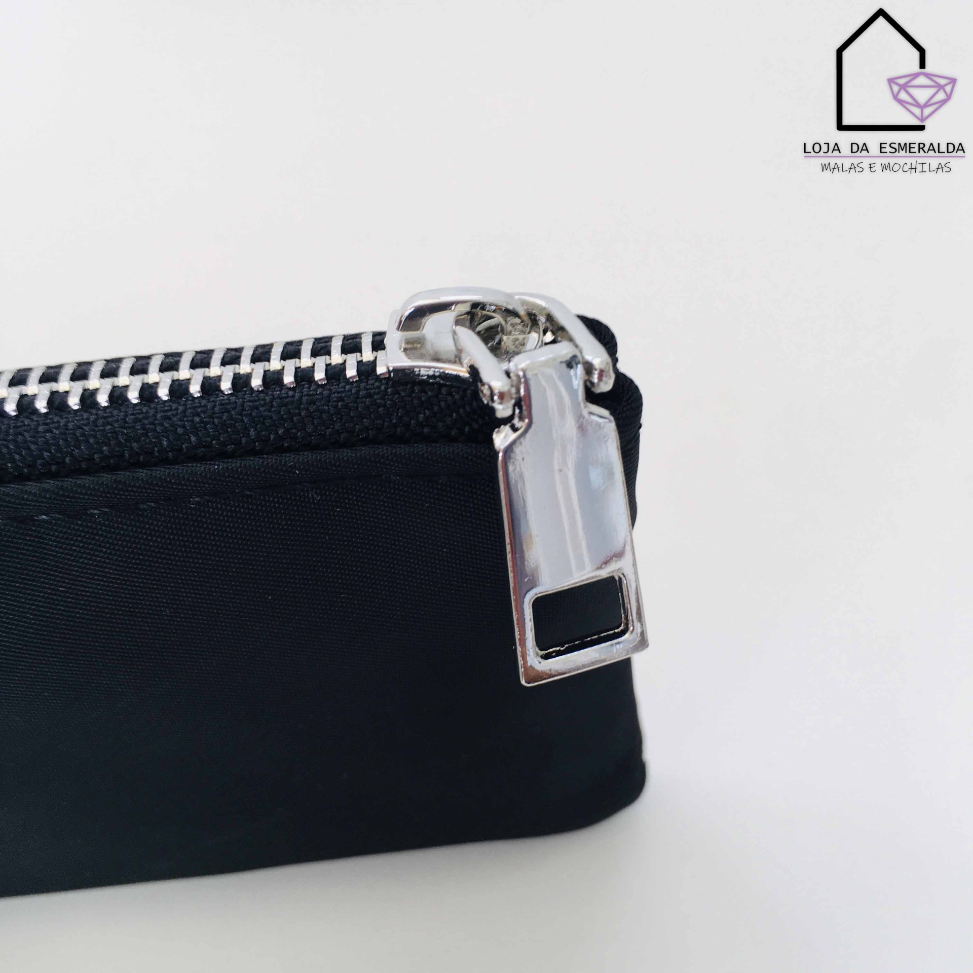 Bolsa preta com fecho metálico prateado sobre fundo branco com logótipo