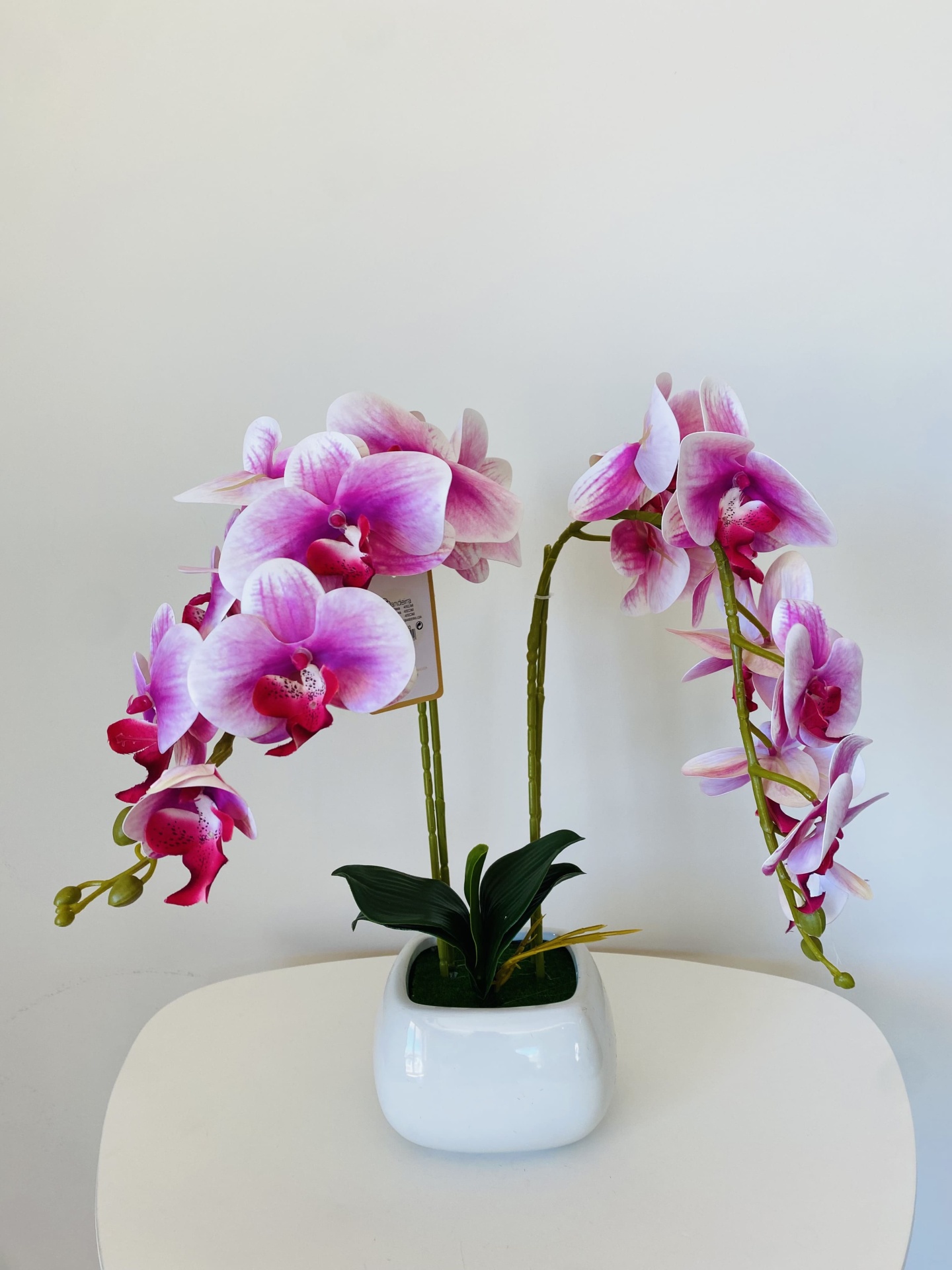 Orquídea artificial rosa e branca em vaso cerâmico branco