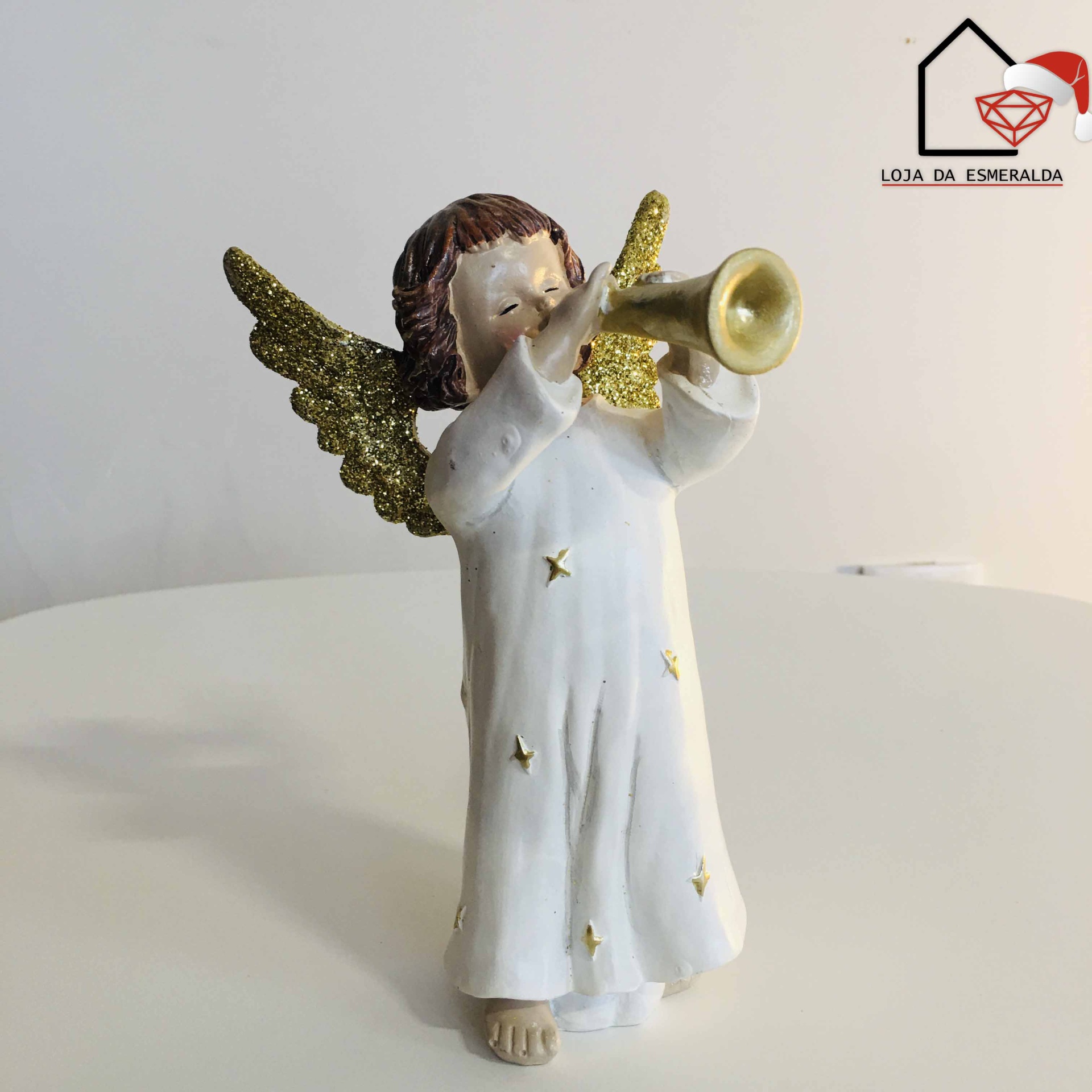 Figurinha de anjo com trompete e asas douradas em fundo claro com logótipo