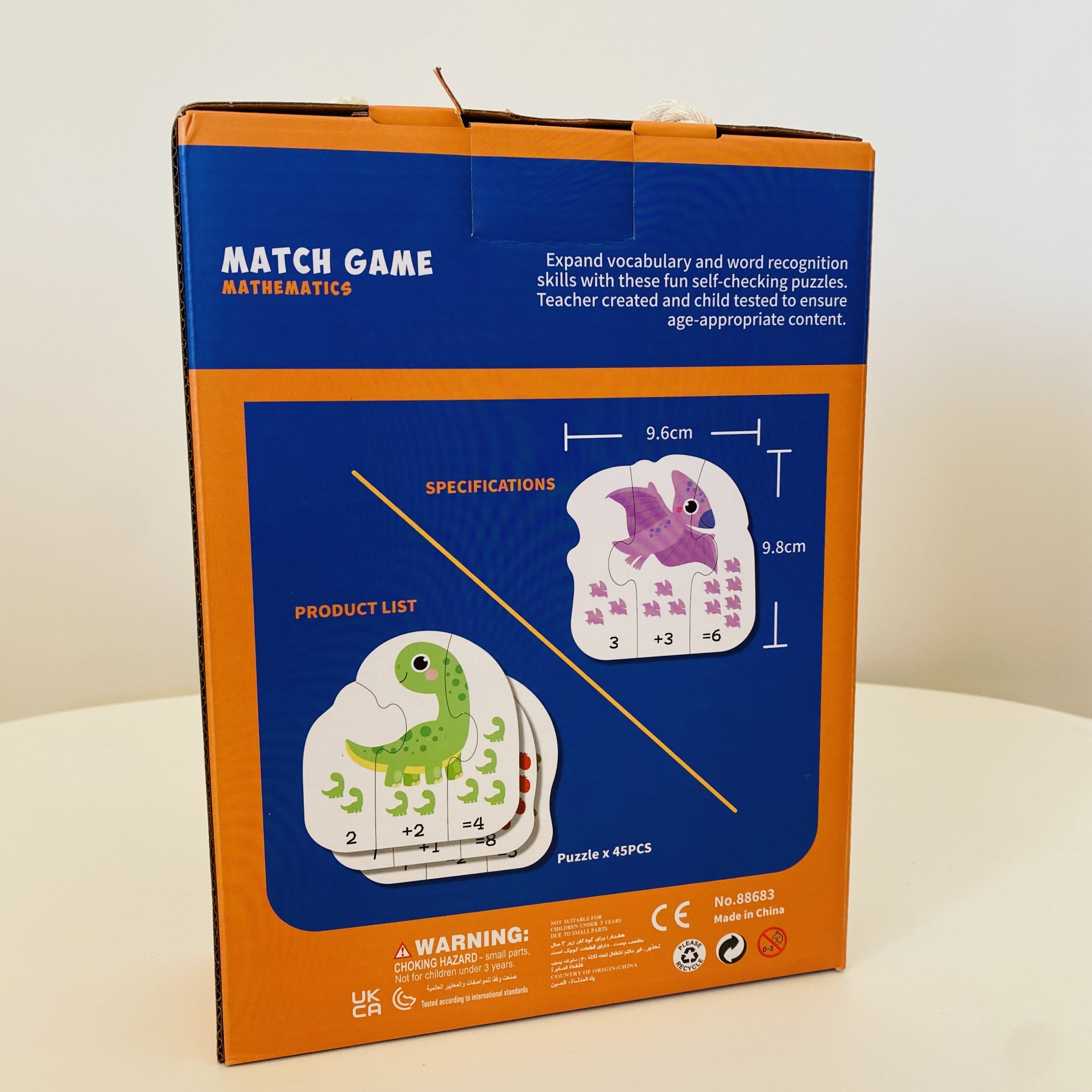 Caixa de jogo de matemática com imagens de dinossauros e texto em inglês