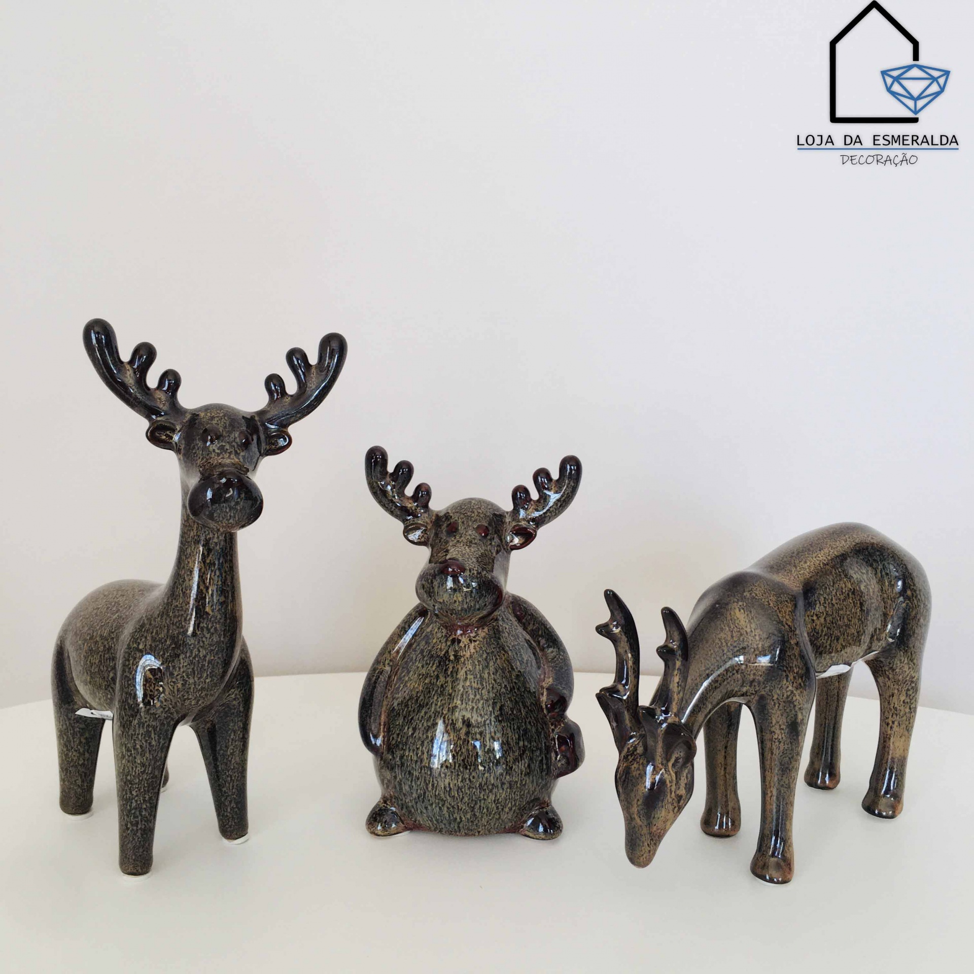 Três estatuetas cerâmicas de renas com acabamento brilhante preto e dourado