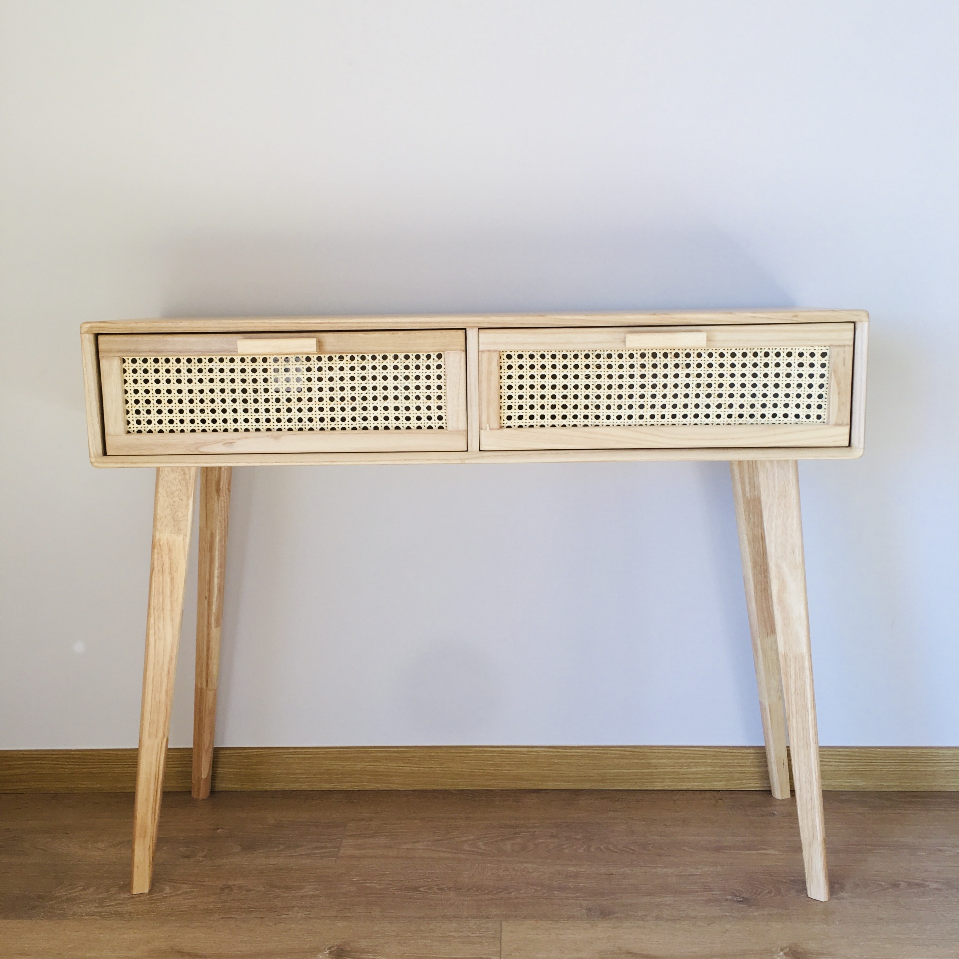 Mesa móvel de madeira clara com duas gavetas de padrão trançado