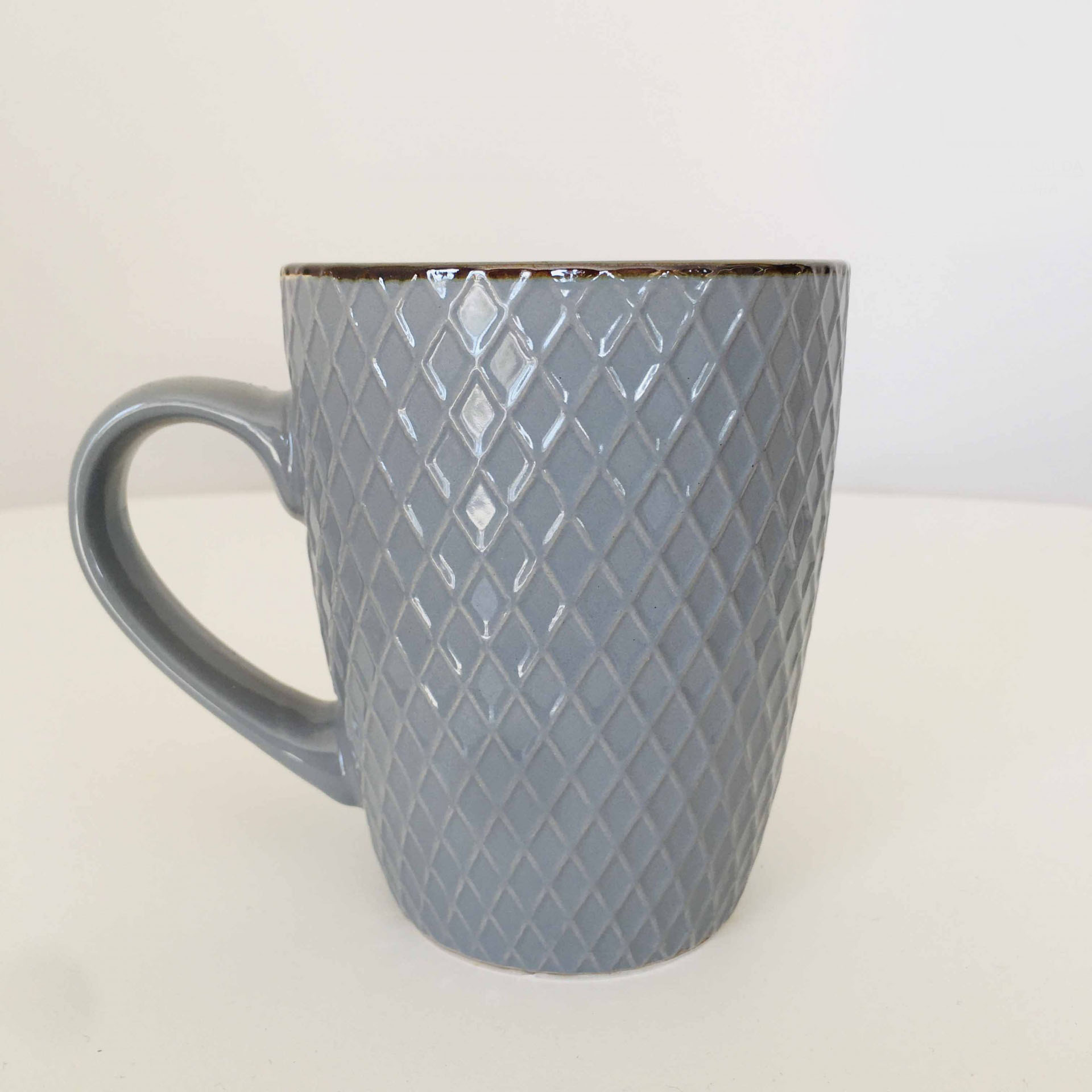 Caneca cinzenta em cerâmica com padrão em relevo de losangos