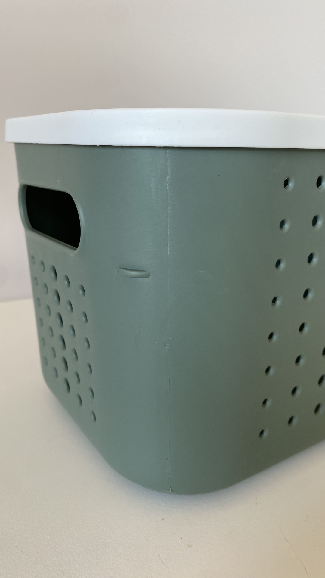 Caixa plástica cinzenta com tampa branca e orifícios redondos