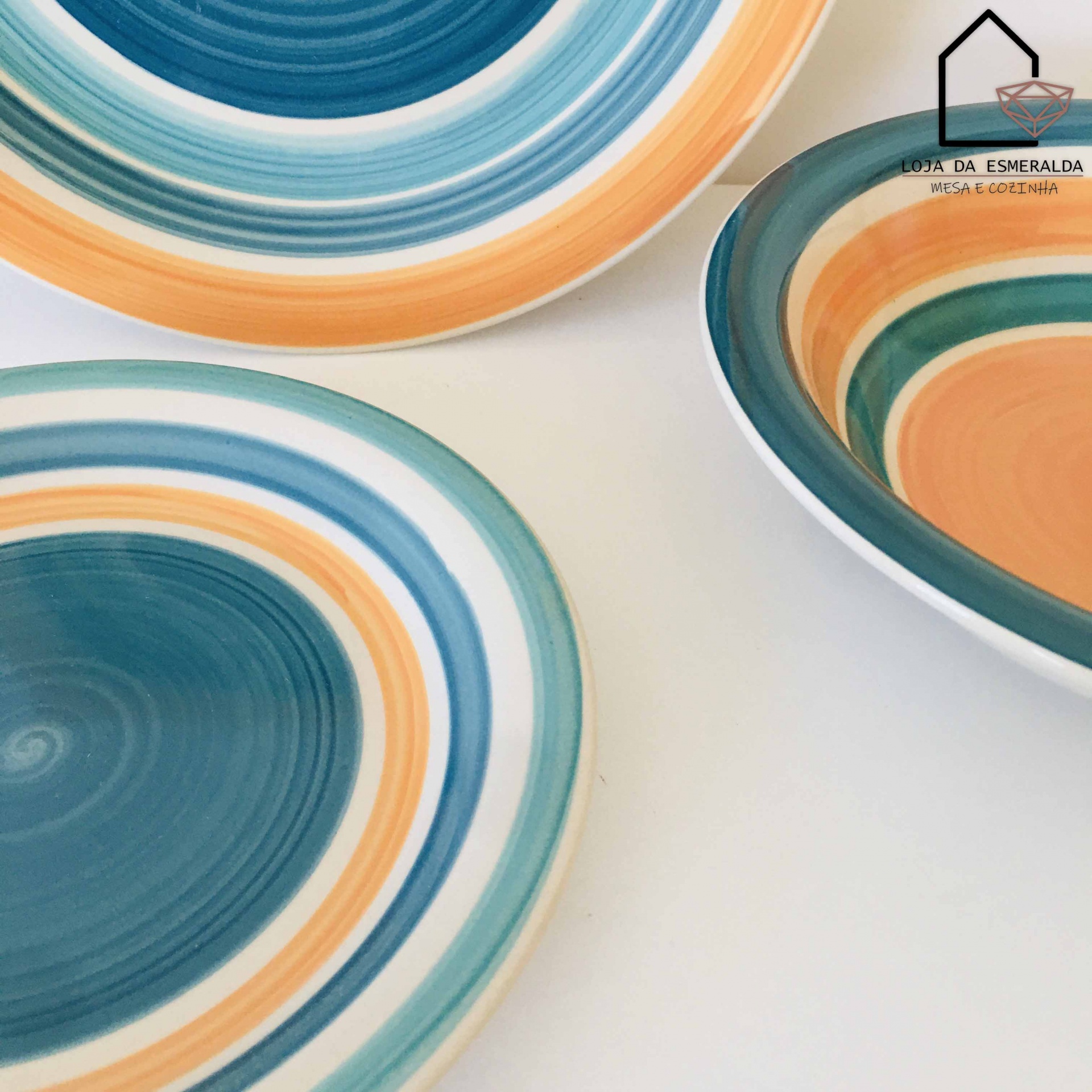 Três pratos coloridos com padrões de anéis concêntricos sobre superfície branca