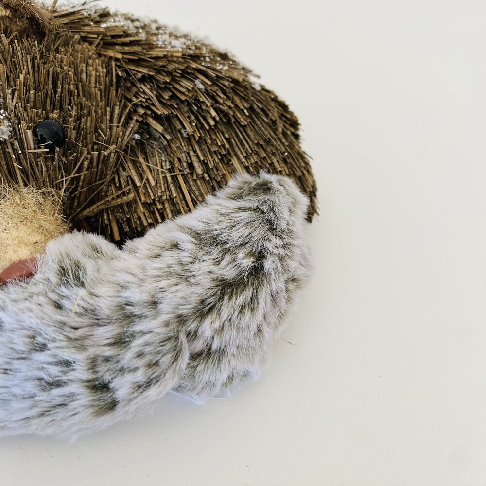 Máscara decorativa com textura de palha castanha e pêlo cinzento com manchas pretas