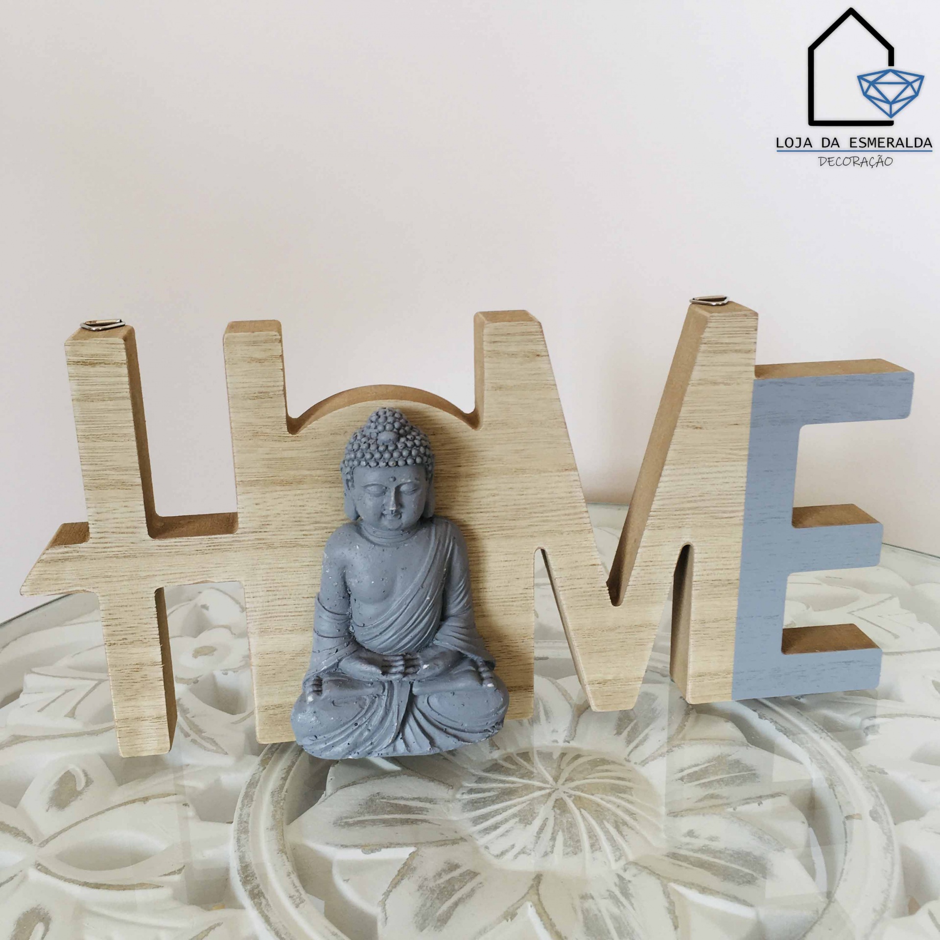 Decoração de madeira formando a palavra LOVE com estátua de Buda cinza no centro.