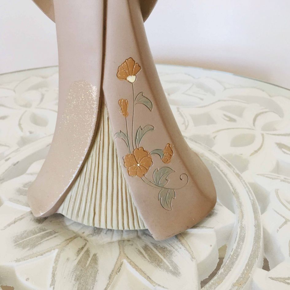 Base de figura decorativa em cerâmica com flores em relevo e superfície branca com padrão floral