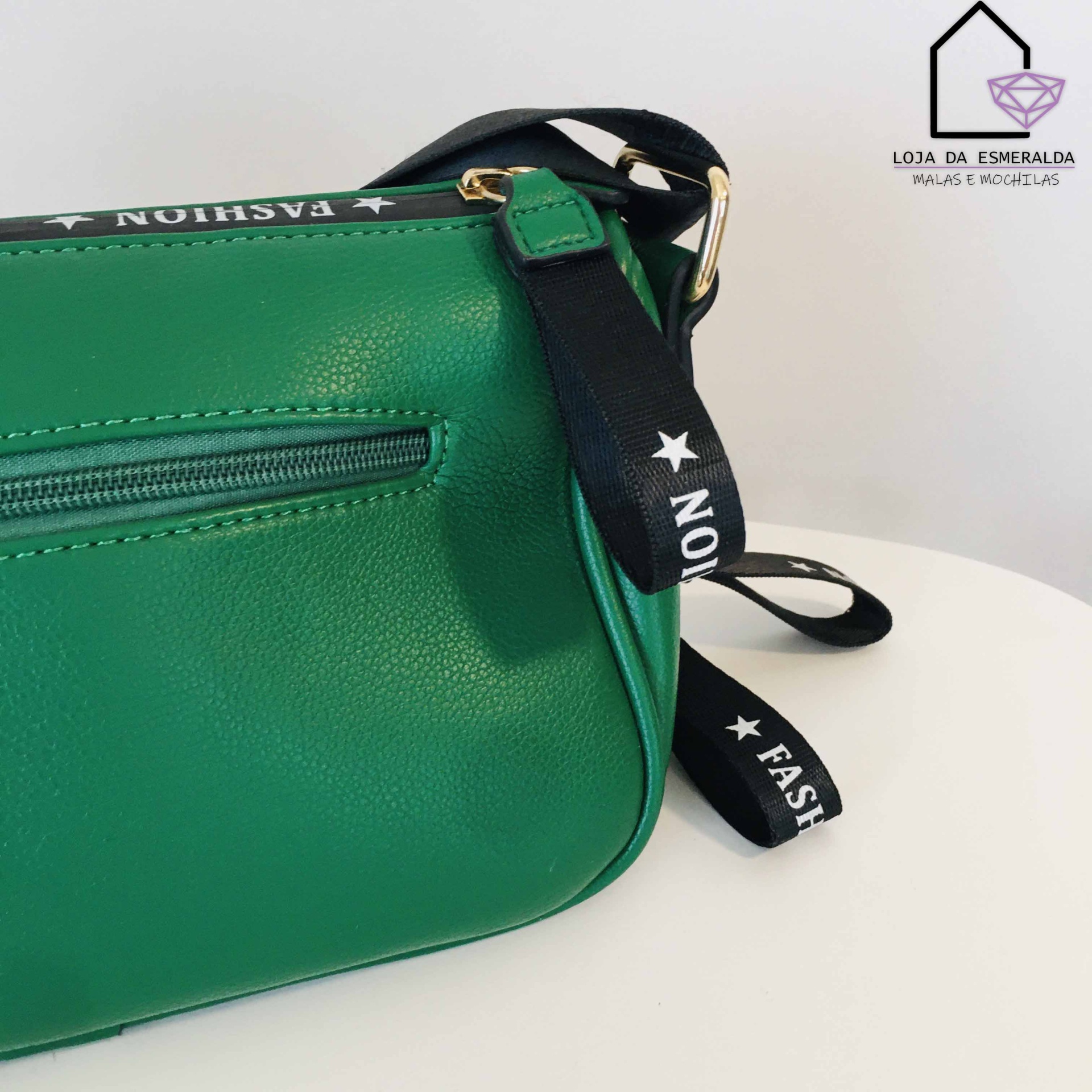 Bolsa verde sintética com alça preta com texto, em fundo branco