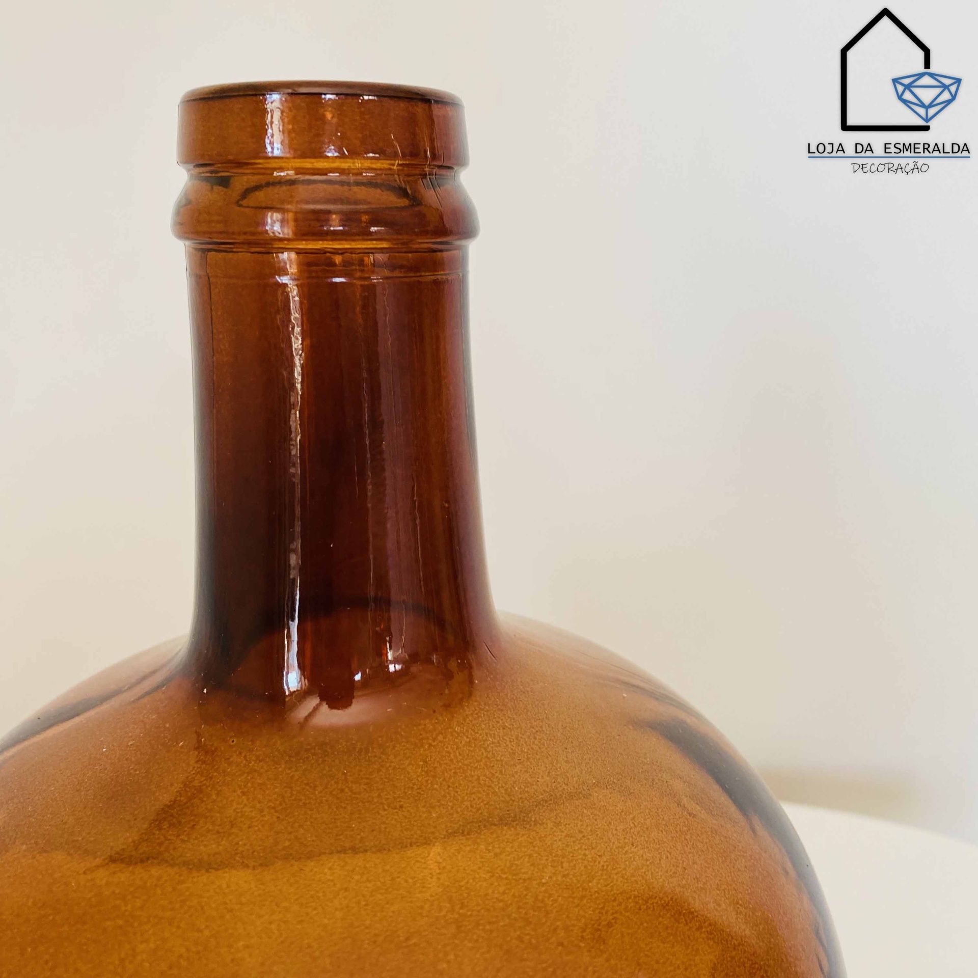 Frasco de vidro castanho com pescoço e rótulo LOJA DA ESMERALDA
