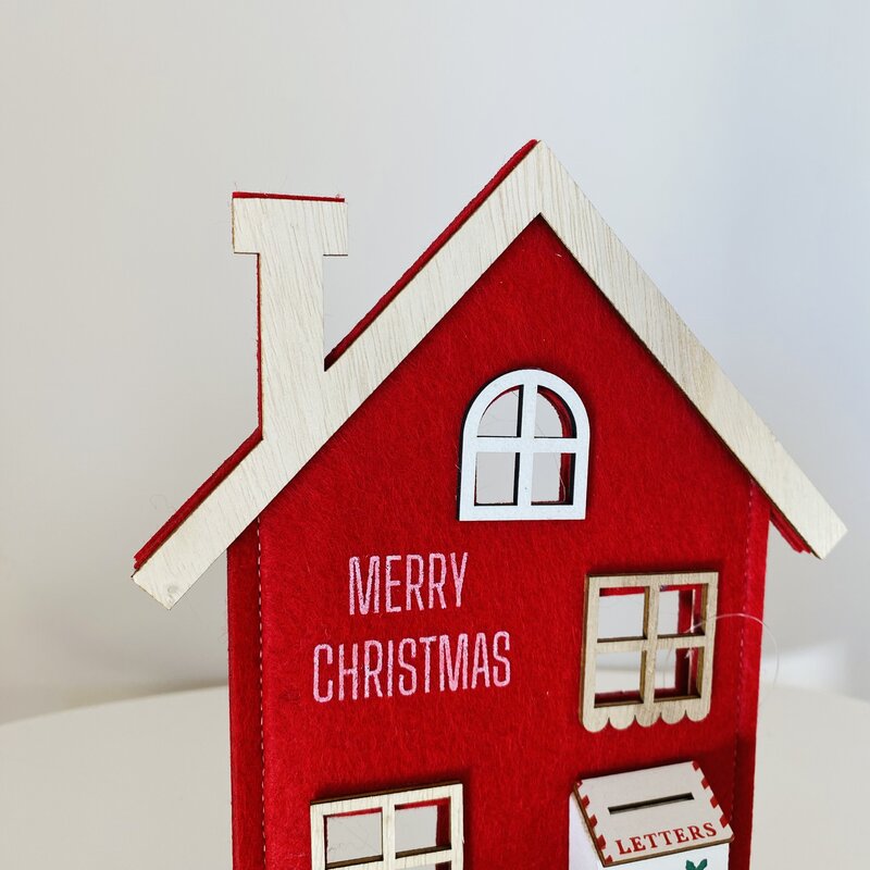 Casinha decorativa vermelha com detalhes em madeira e inscrições de Natal