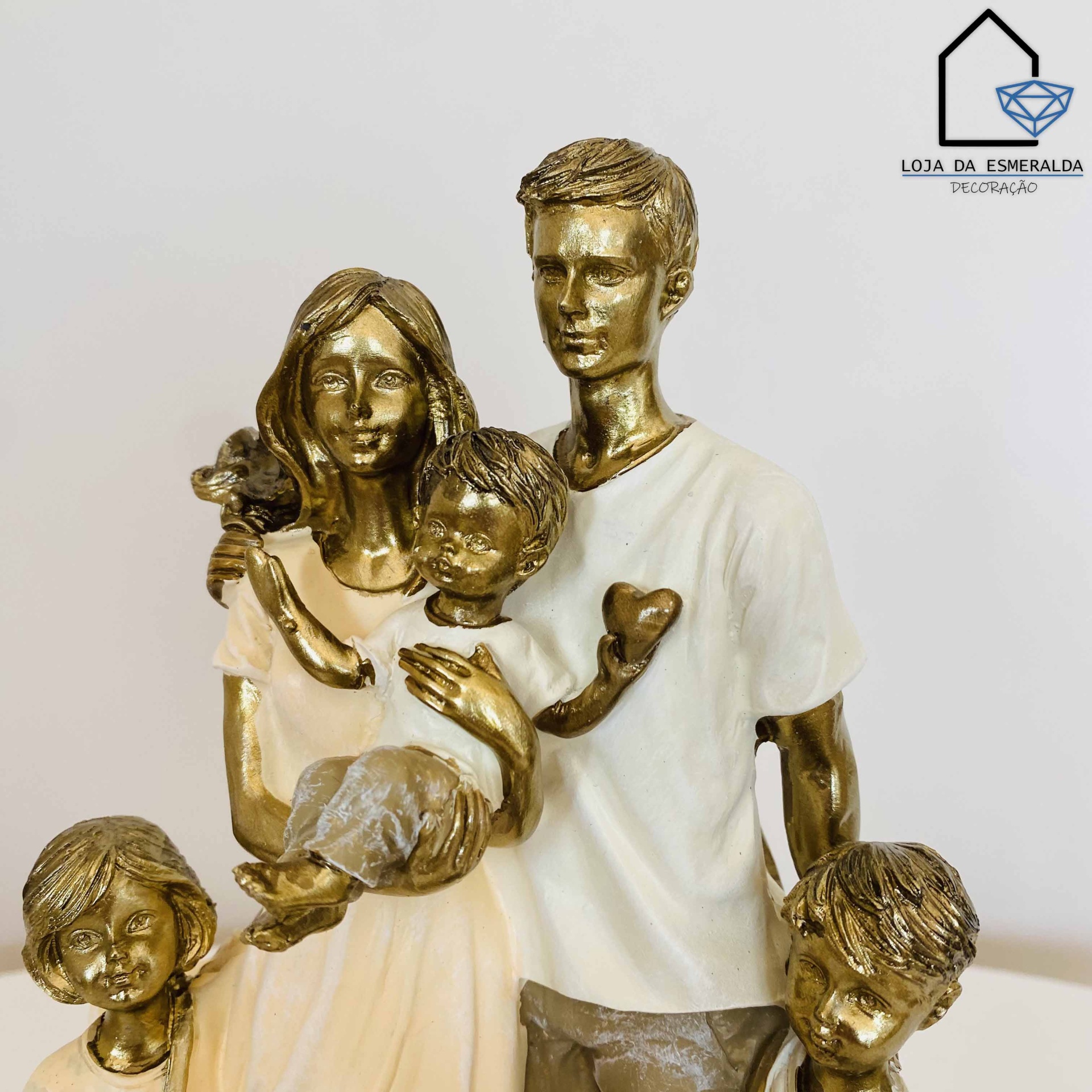Escultura decorativa de família com quatro figuras em tons bege, castanho e branco com logótipo Loja da Esmeralda