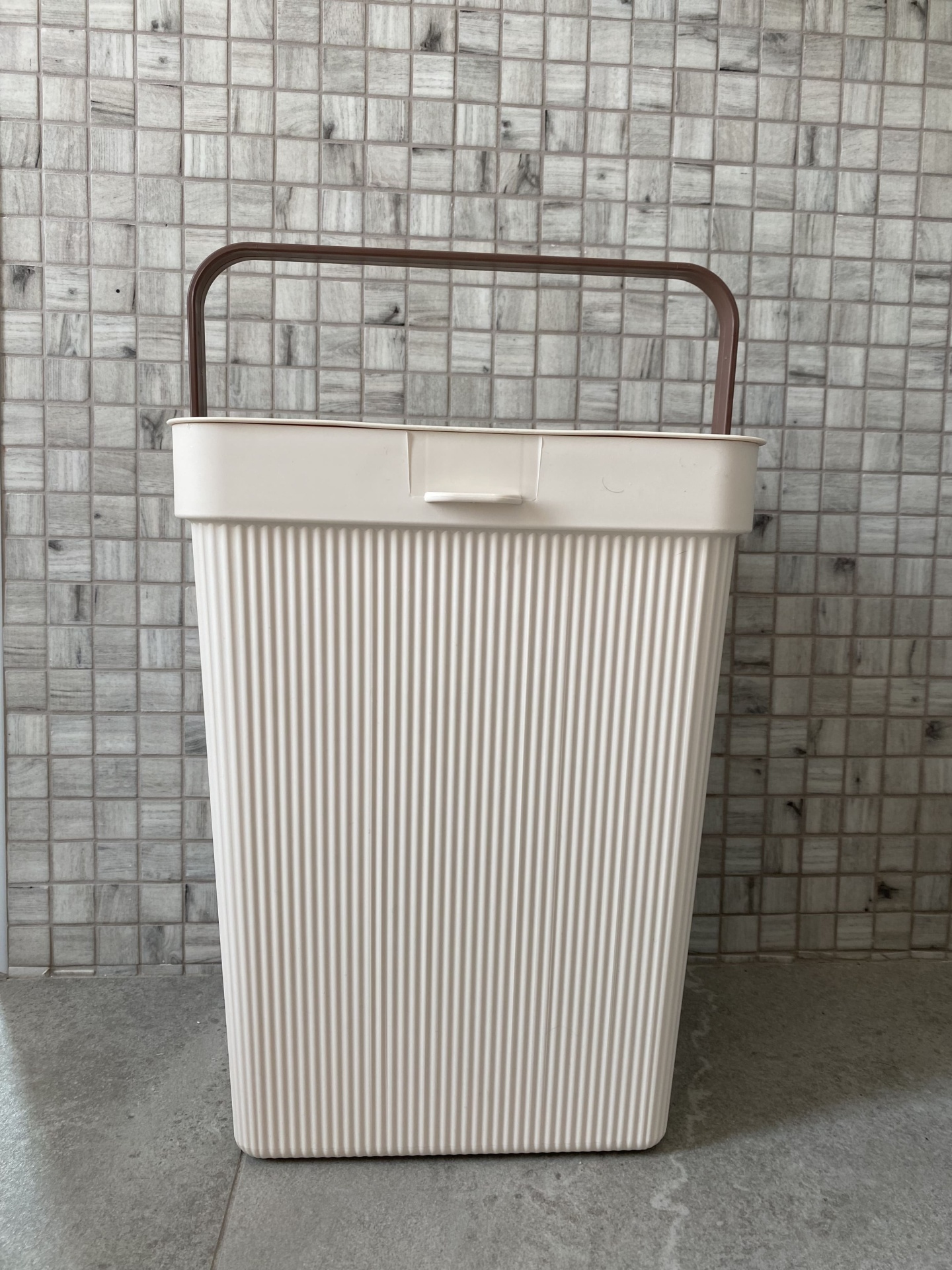 Cesto de plástico creme com pega castanha e textura em linhas verticais