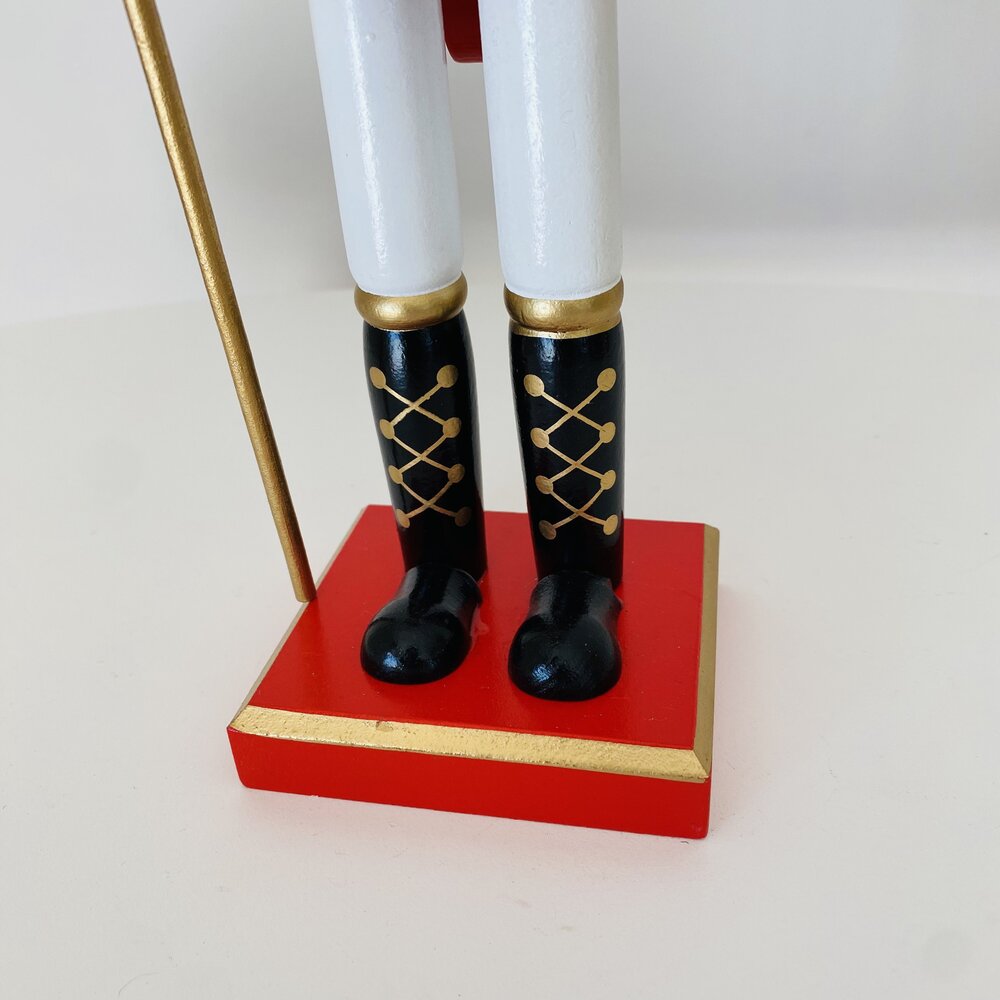 Base vermelha com detalhes dourados e botas pretas com laços dourados de figura decorativa