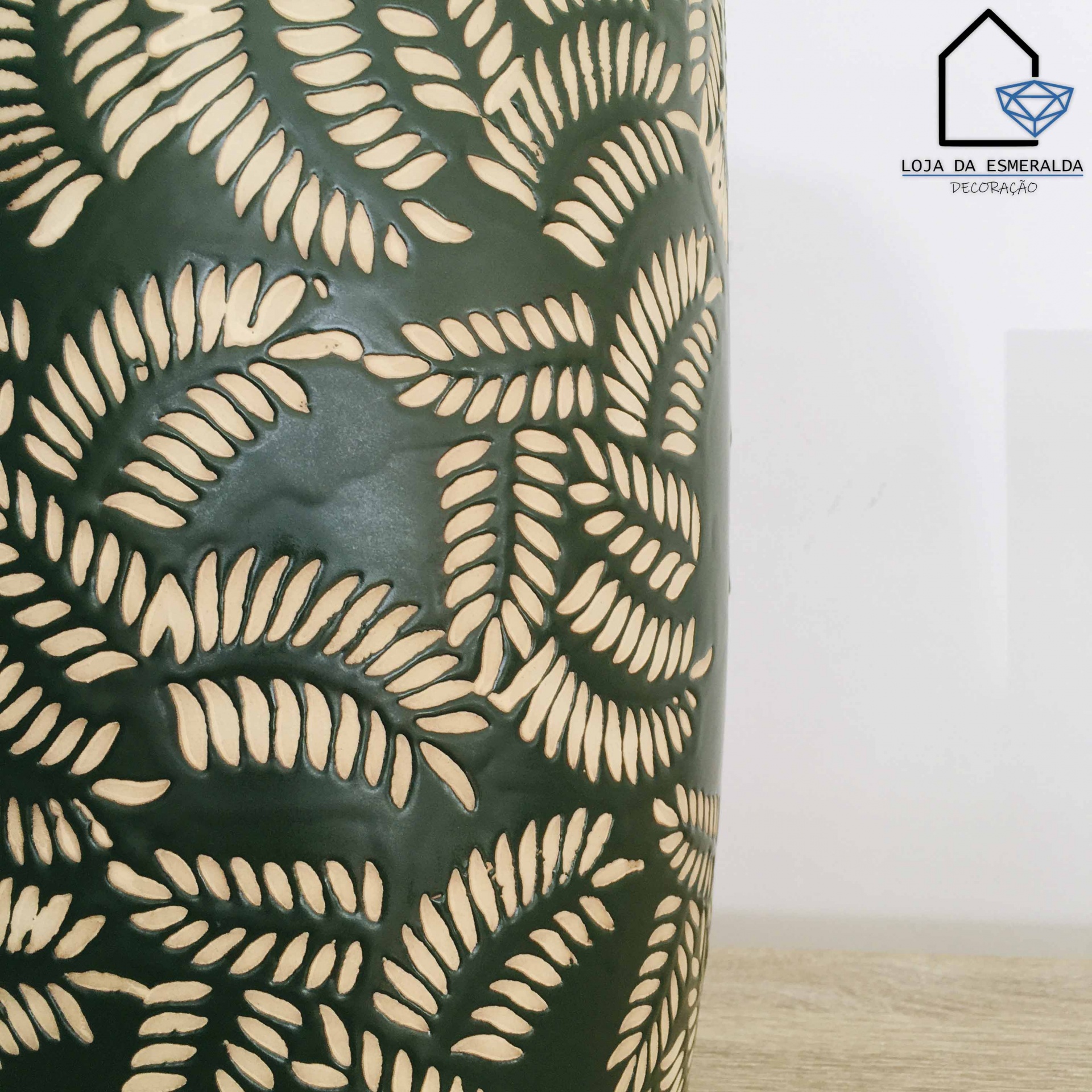 Vaso verde com padrão de folhas recortadas em madeira