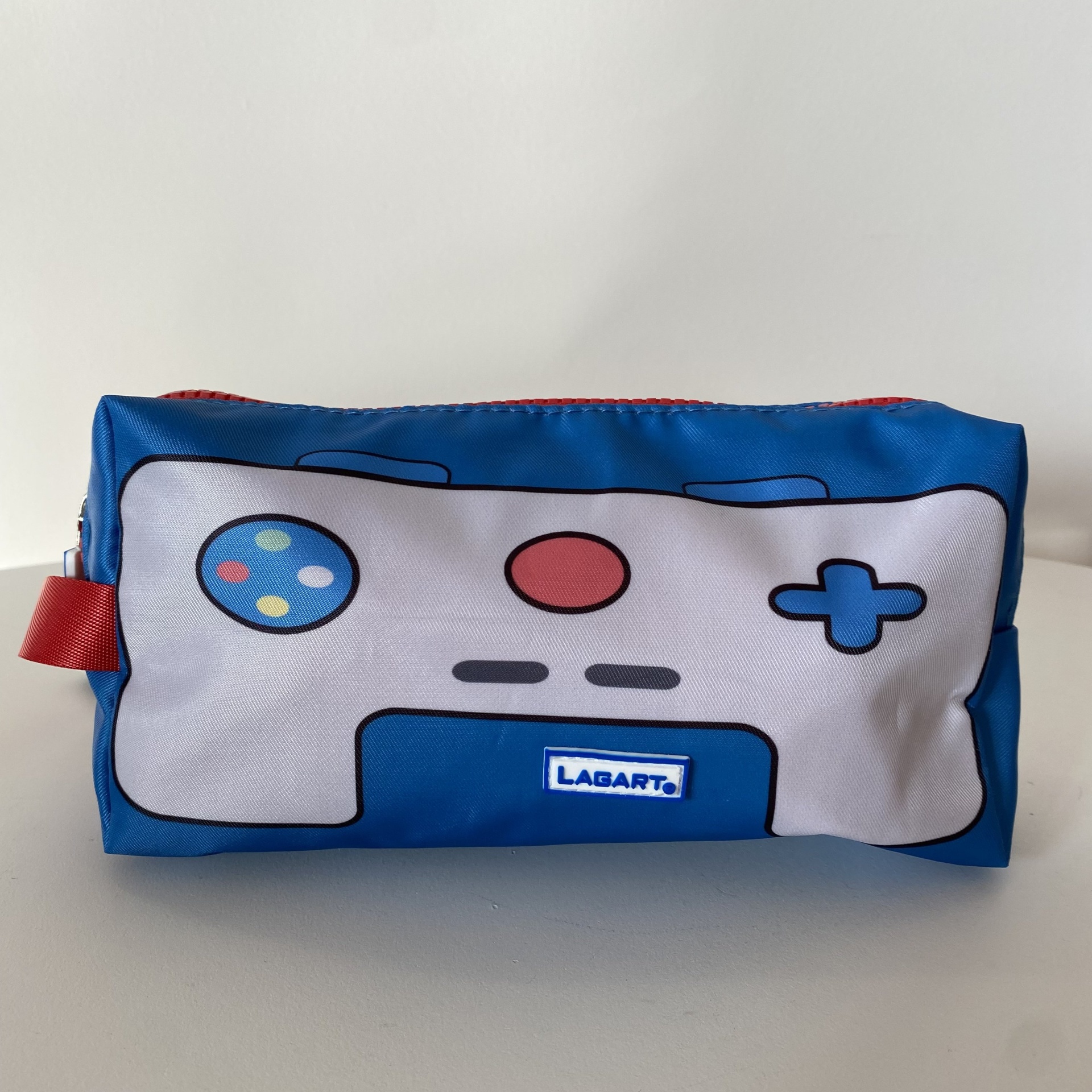 Estojo azul com estampa de comando de videojogo e etiqueta Lagart