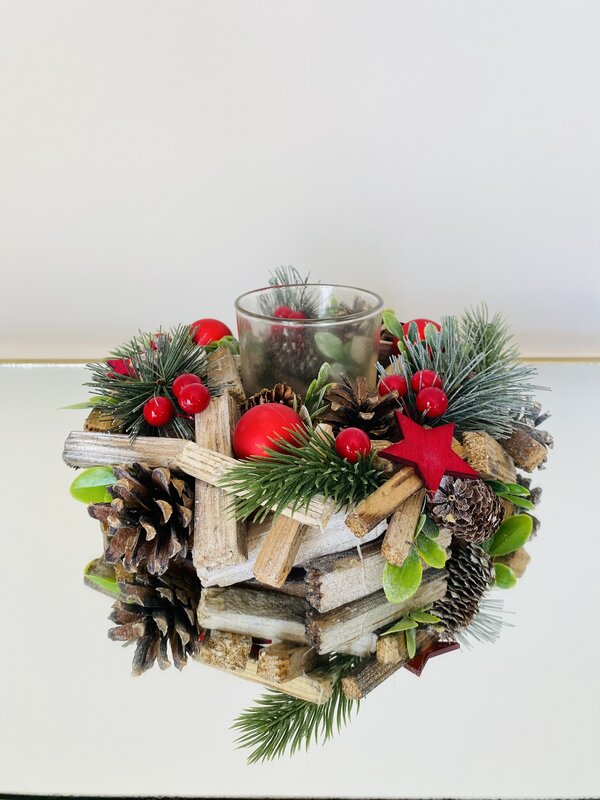 Coroa decorativa de Natal com paus de madeira, pinhas, ramos de pinheiro, bagas vermelhas e uma estrela vermelha