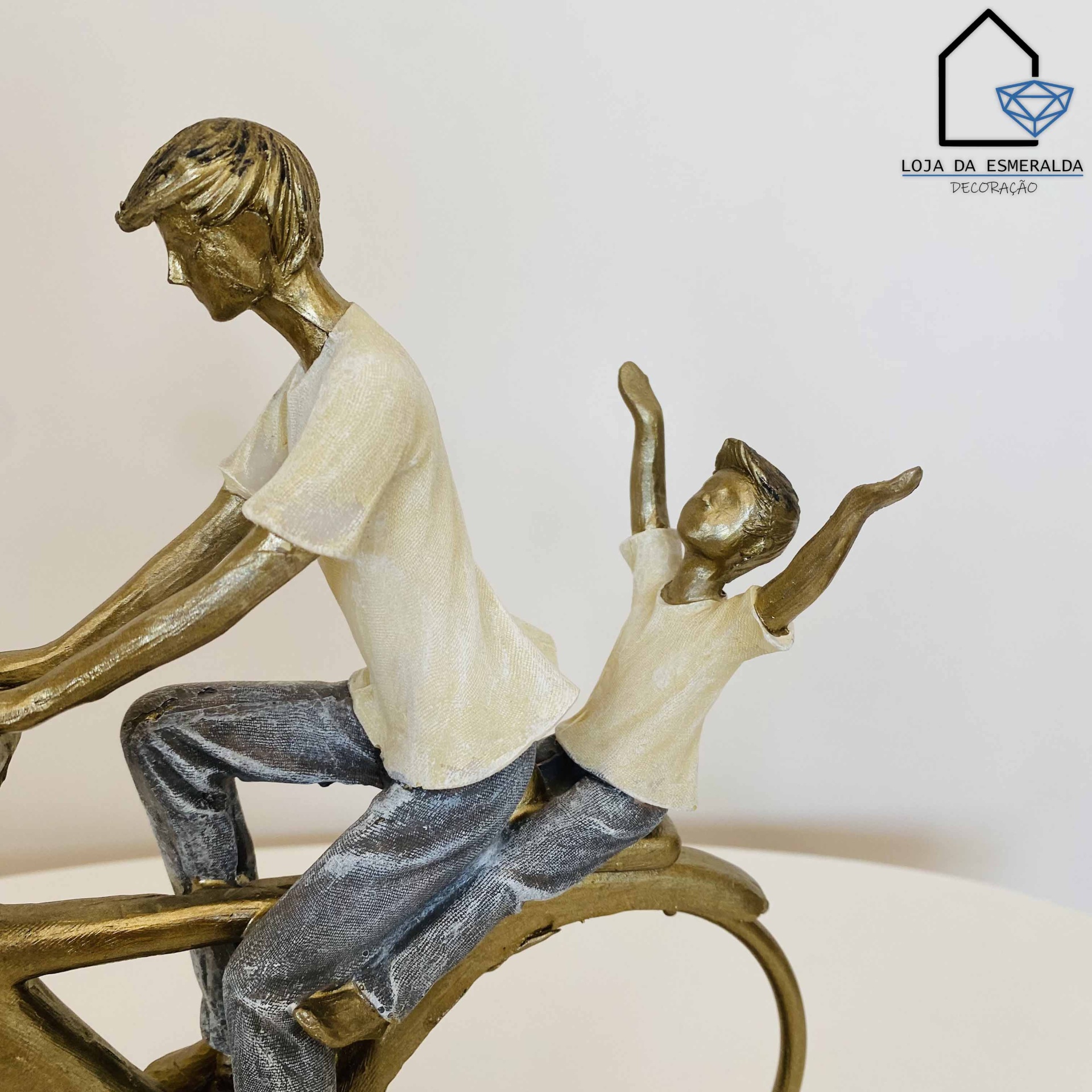 Escultura decorativa de duas figuras masculinas em bicicleta com logótipo de loja