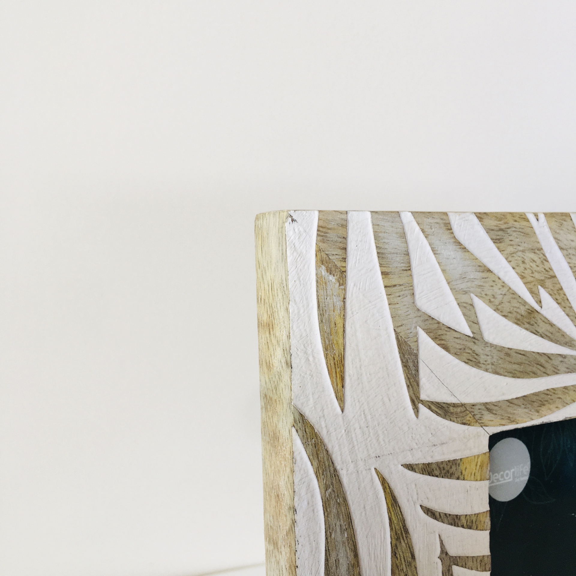 Canto de moldura de madeira com padrão branco em fundo branco