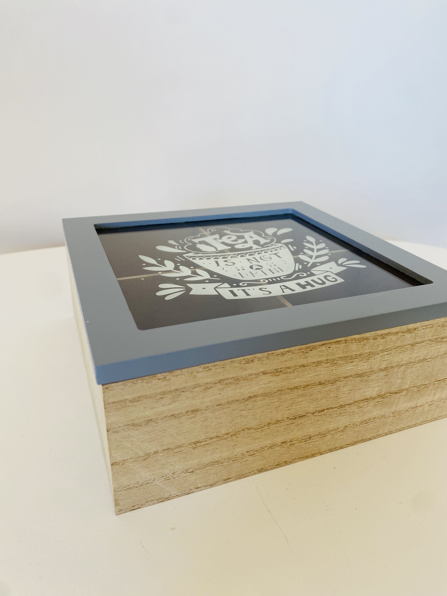 Caixa decorativa quadrada em madeira com tampa cinza e gravação de texto branco