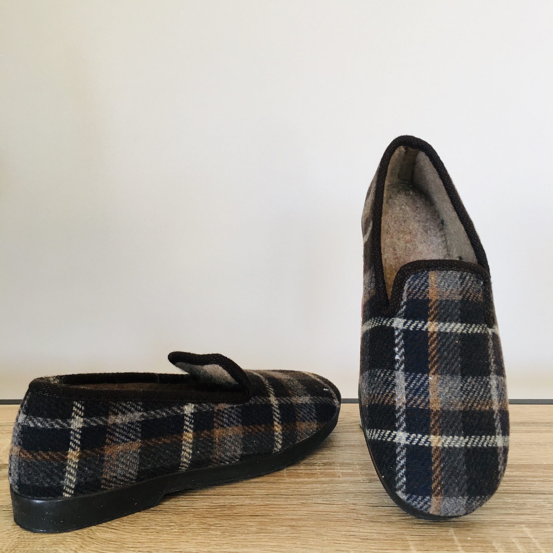 Chinelos femininos com padrão xadrez em preto, cinza e castanho e forro felpudo