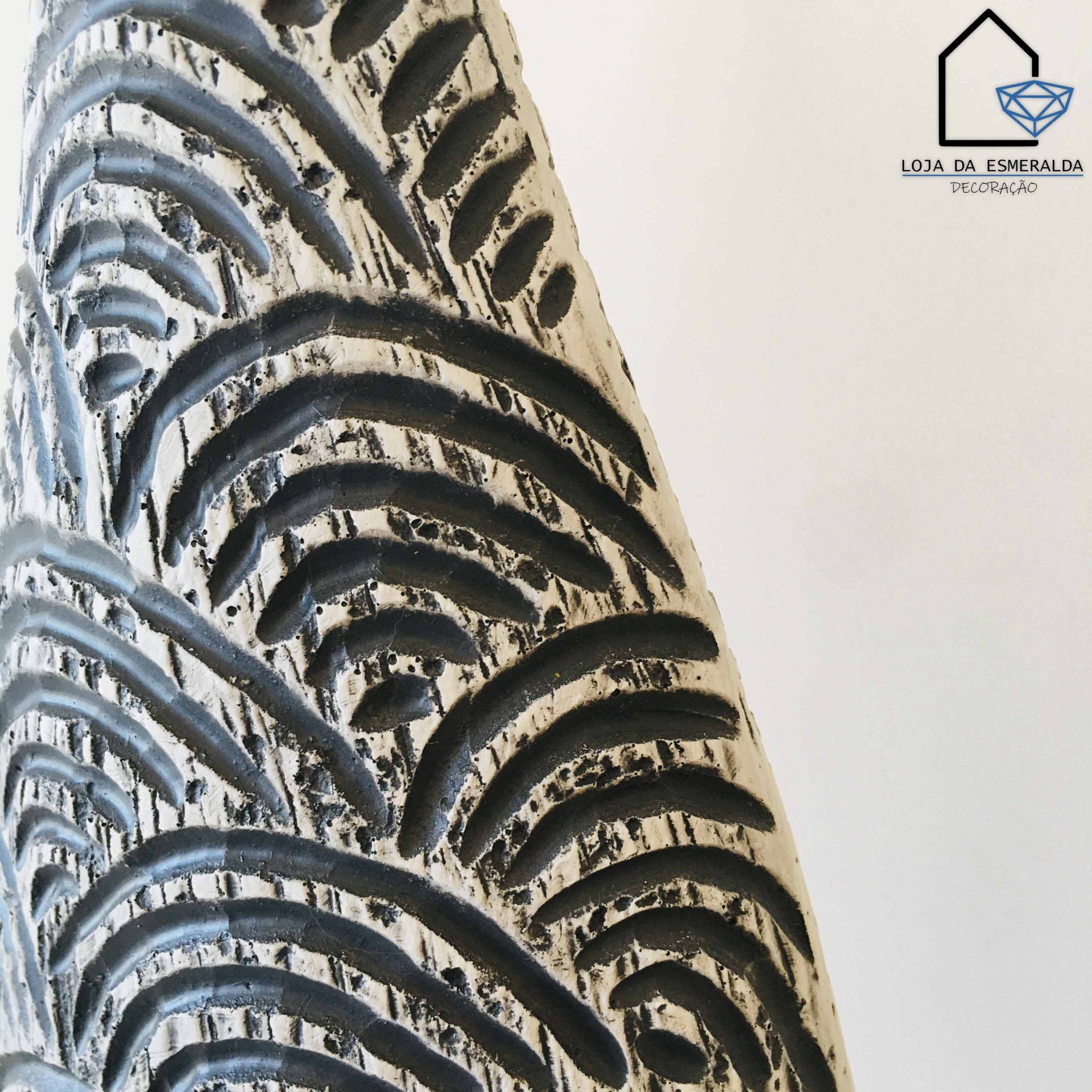 Pormenor de objeto decorativo branco com padrões abstractos em relevo preto