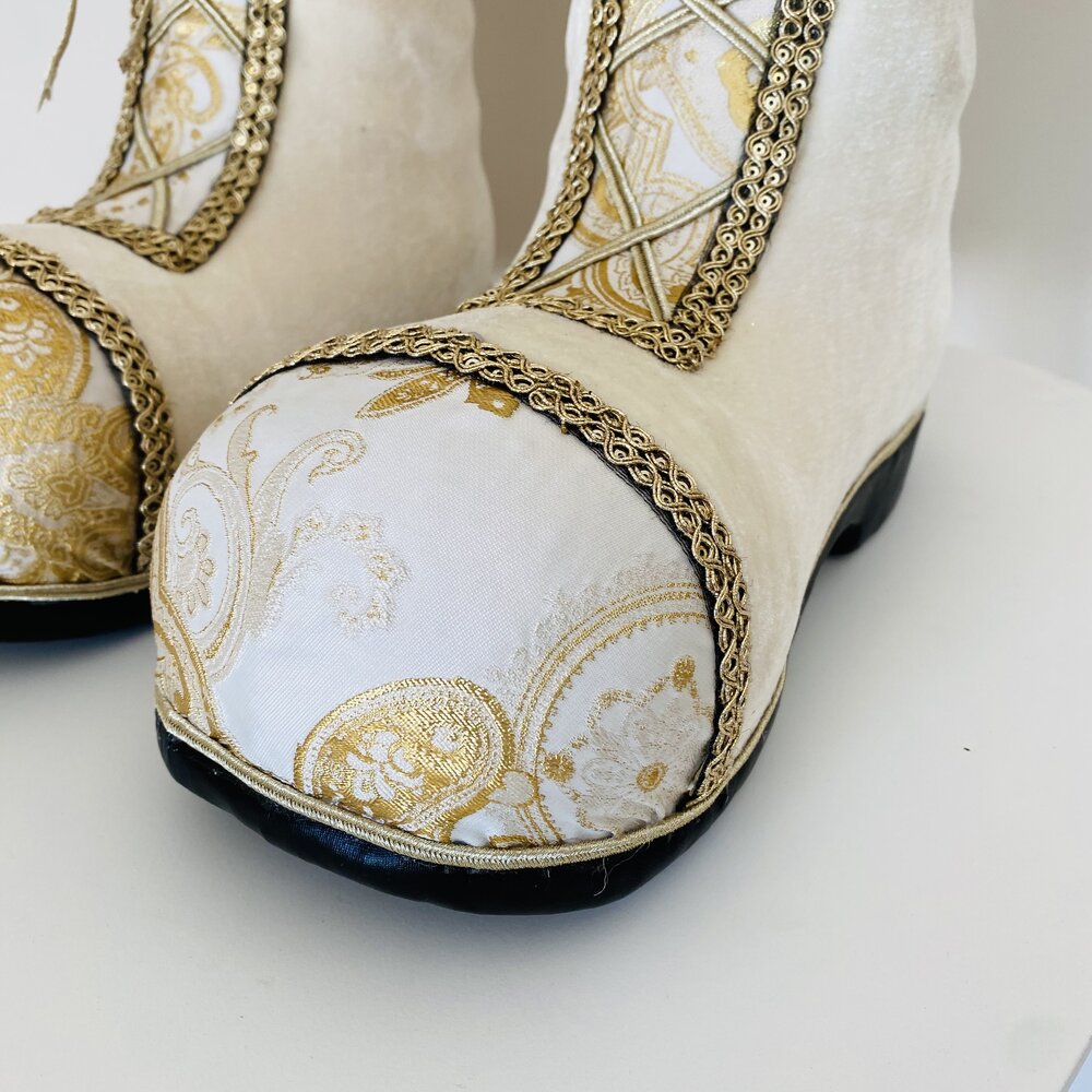 Botas creme com padrão dourado e detalhes bordados, sola preta