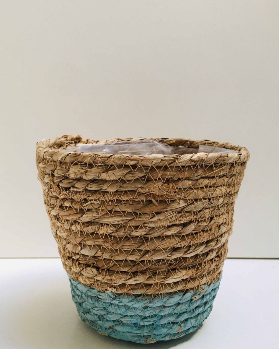 Cesto trançado de fibras naturais com base azul e parte superior bege