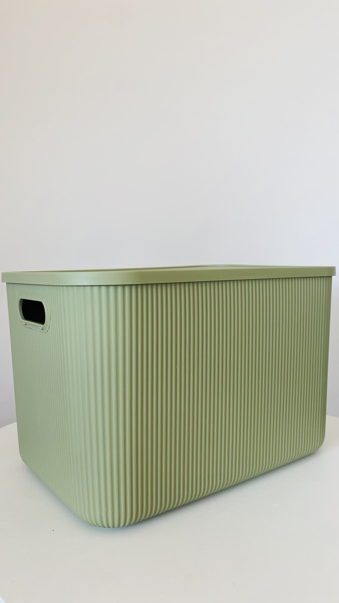 Caixa de arrumação verde claro com tampa e textura de ranhuras verticais