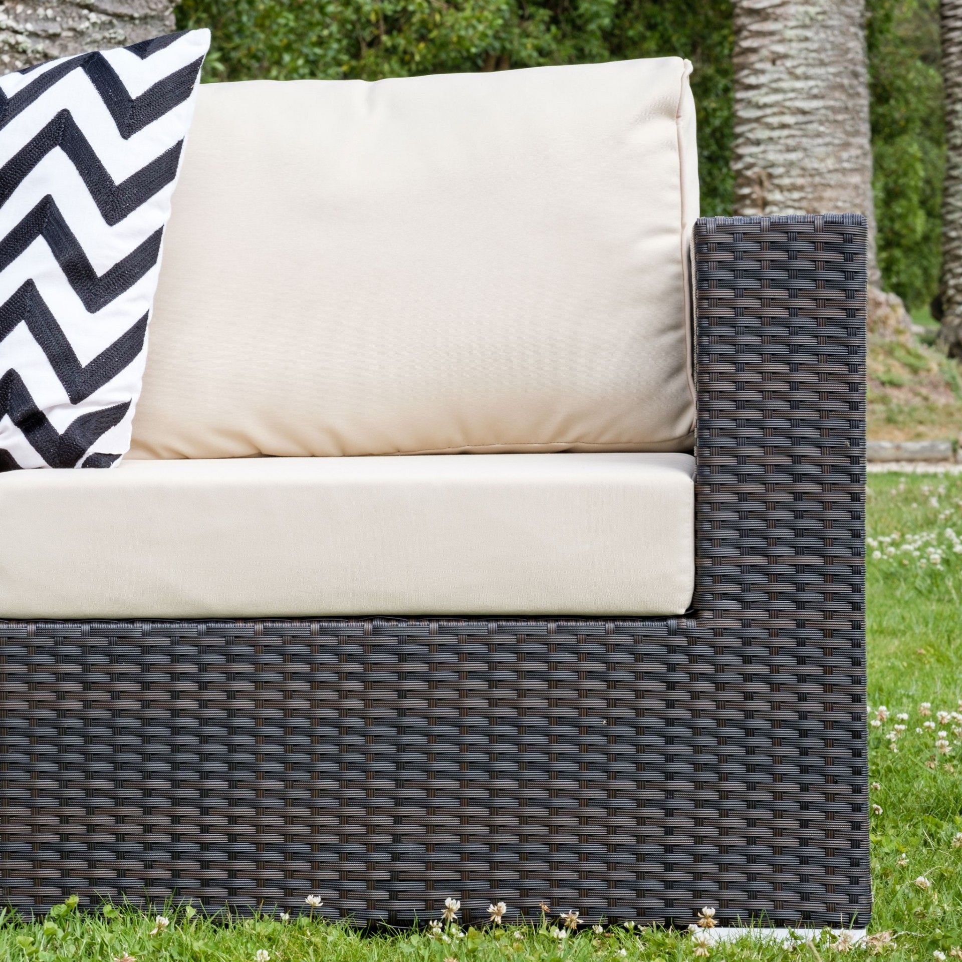 Sofá de jardim em vime sintético castanho escuro com almofadas bege e almofada decorativa branco e preto