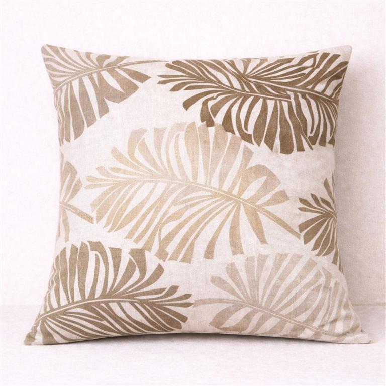 Almofada quadrada com padrão de folhas em tons bege e castanho
