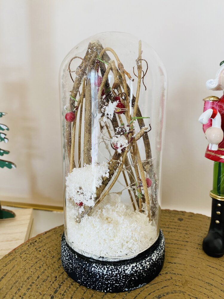 Domo decorativo com galhos, bagas vermelhas e neve artificial