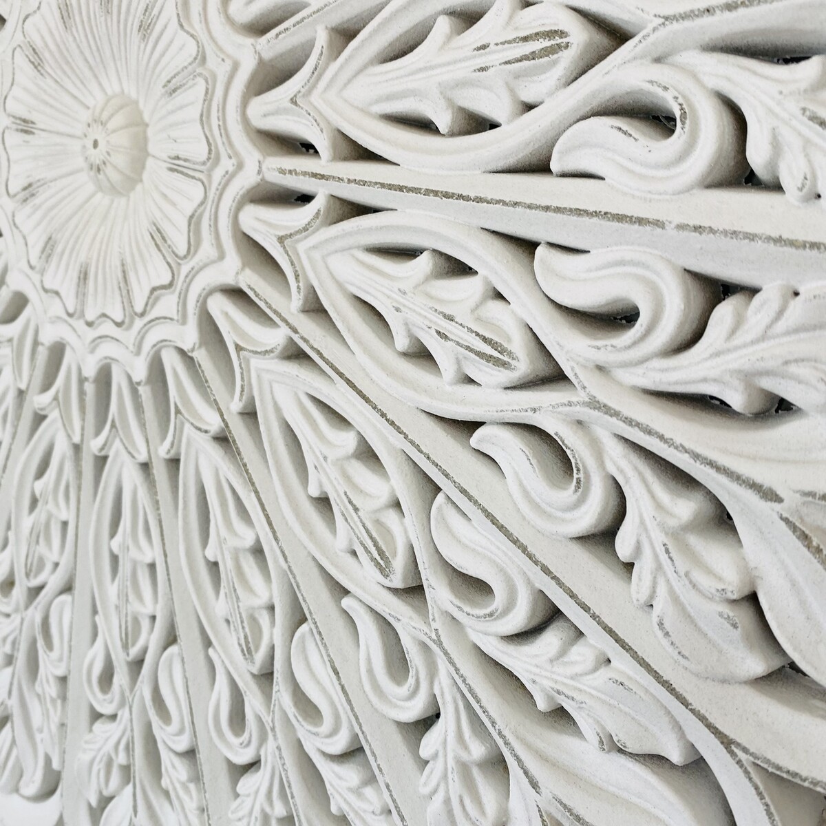 Relevo decorativo branco com padrões florais e espirais em acabamento mate.