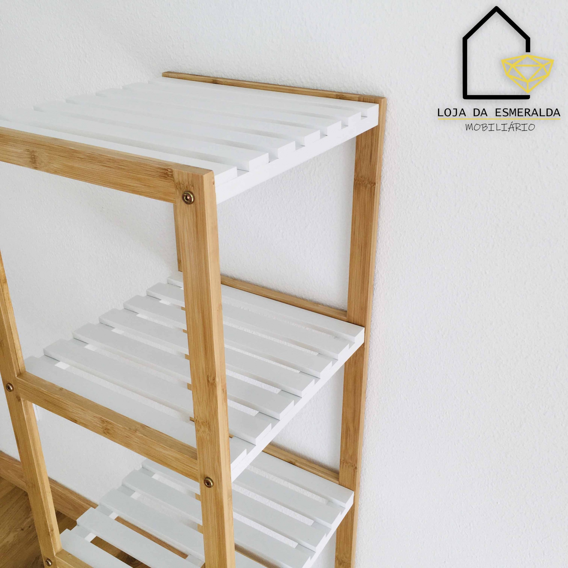 Prateleira de madeira com ripas brancas e logótipo Loja da Esmeralda na parede