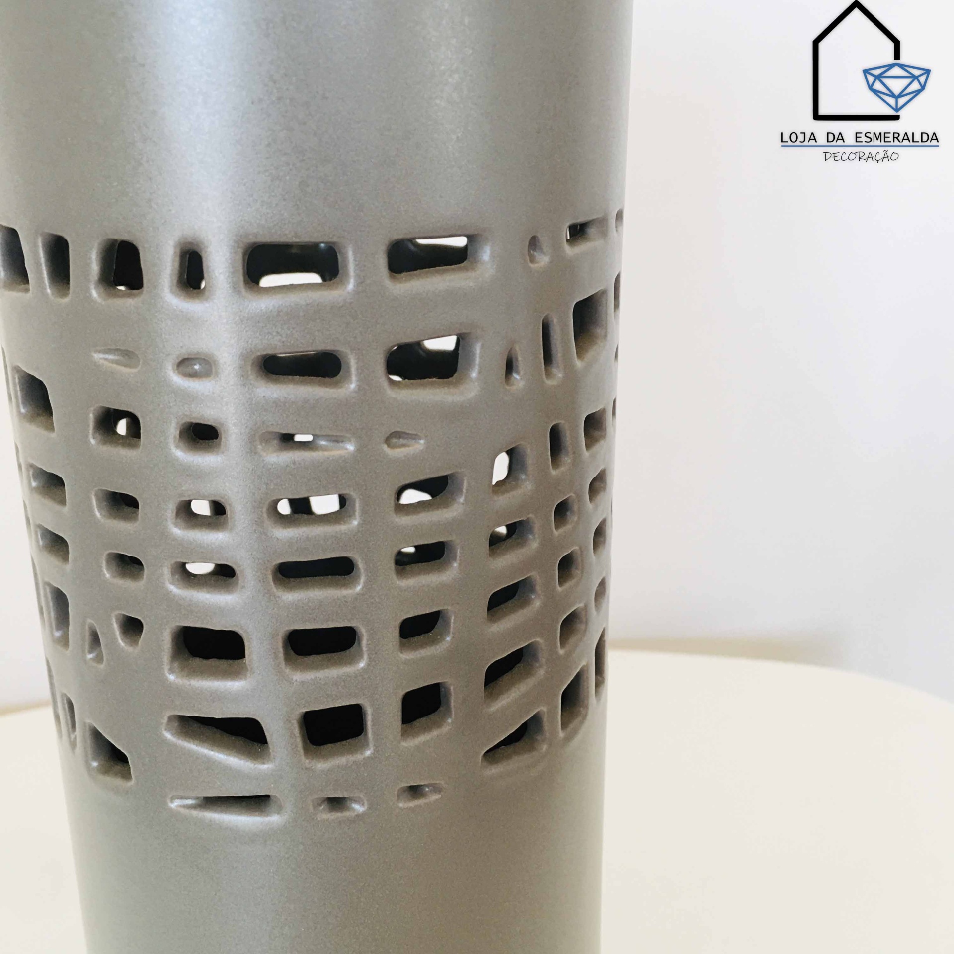 Vaso cinza com recortes geométricos em fundo branco
