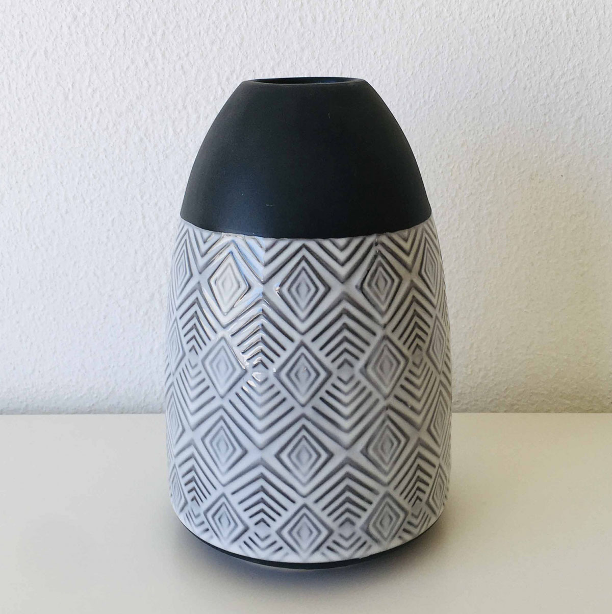 Vaso decorativo preto fosco e branco com padrão geométrico em relevo