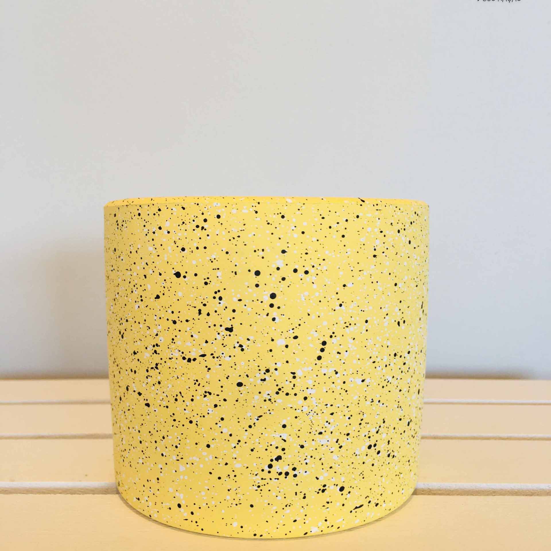 vaso cilíndrico amarelo com padrão salpicado preto e branco