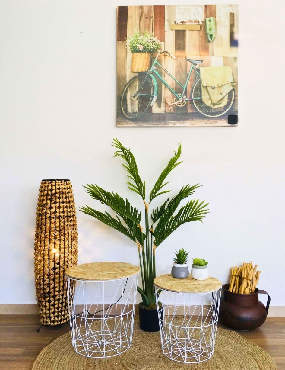 estante de cesto branco com tampo de madeira, plantas e candeeiro de palha
