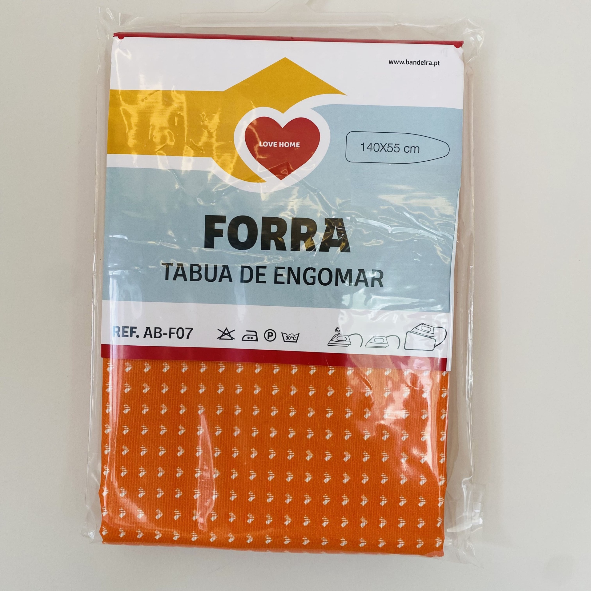 Forra para tábua de engomar laranja com padrão trinagular, embalagem com etiqueta Love Home