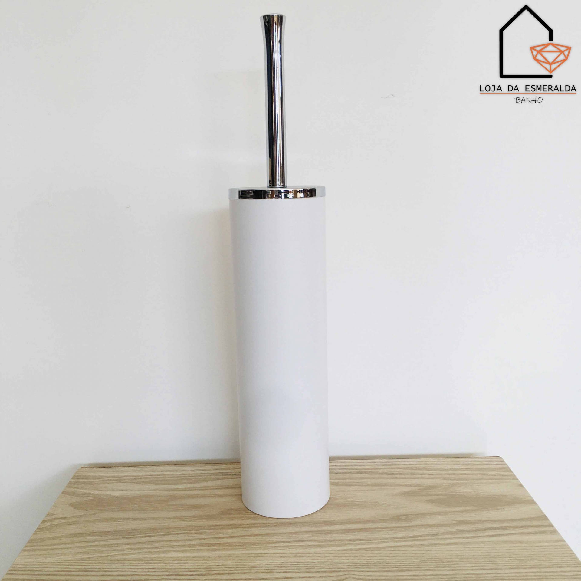 Escova sanitária branca com cabo metálico sobre superfície de madeira